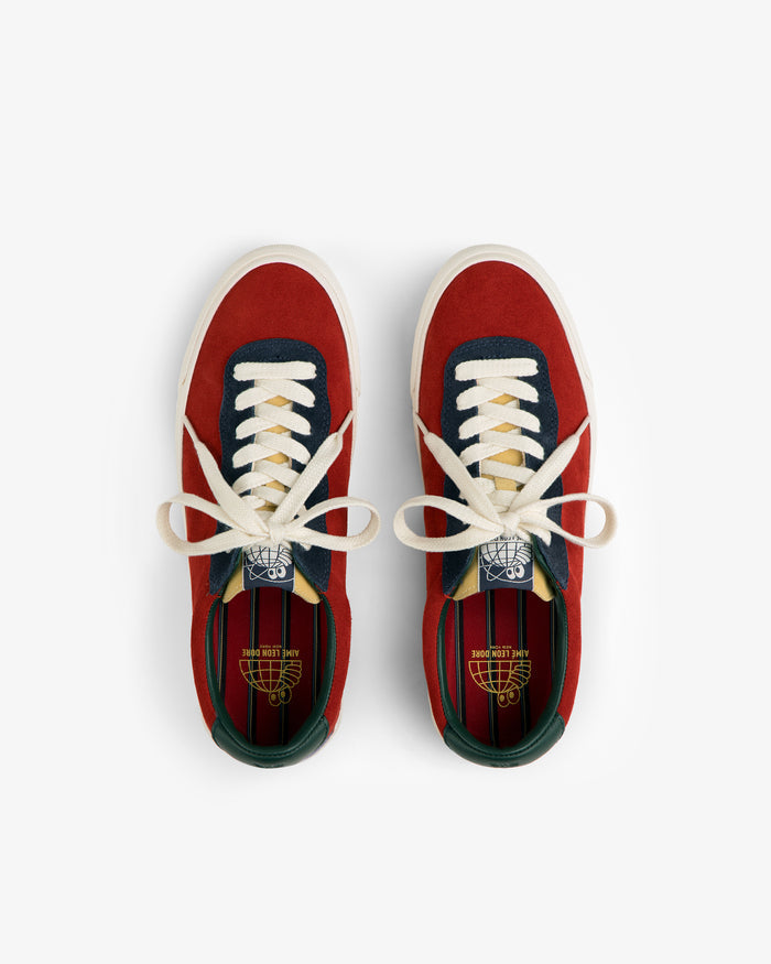 ALD / Last Resort AB VM001-LO Suede red sneakers with white laces, navy and green accents, top view on white background.