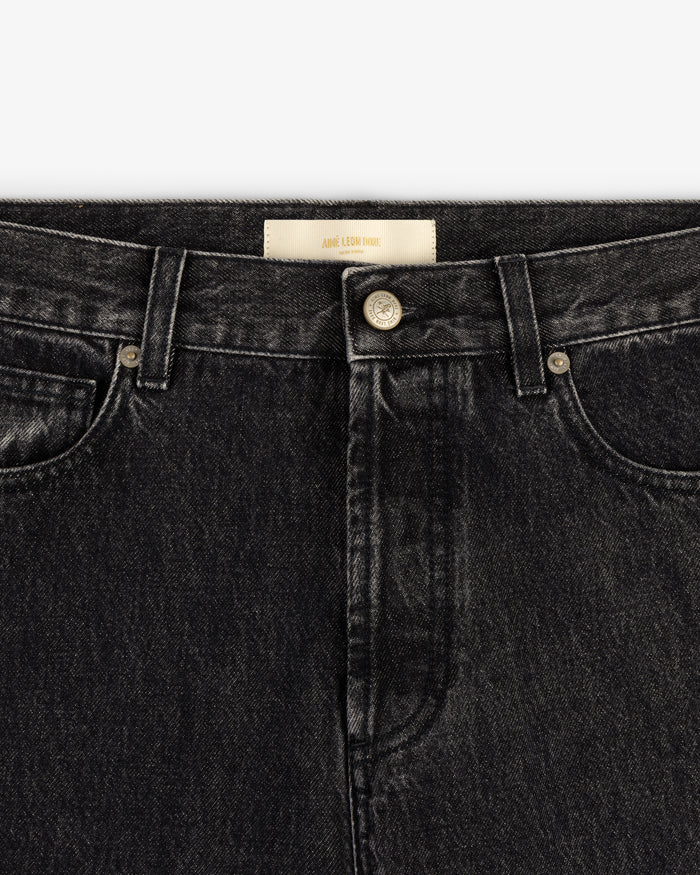 Close-up of waistband and front of Relaxed Fit 5-Pocket Denim Pant in black with metal button and belt loops.