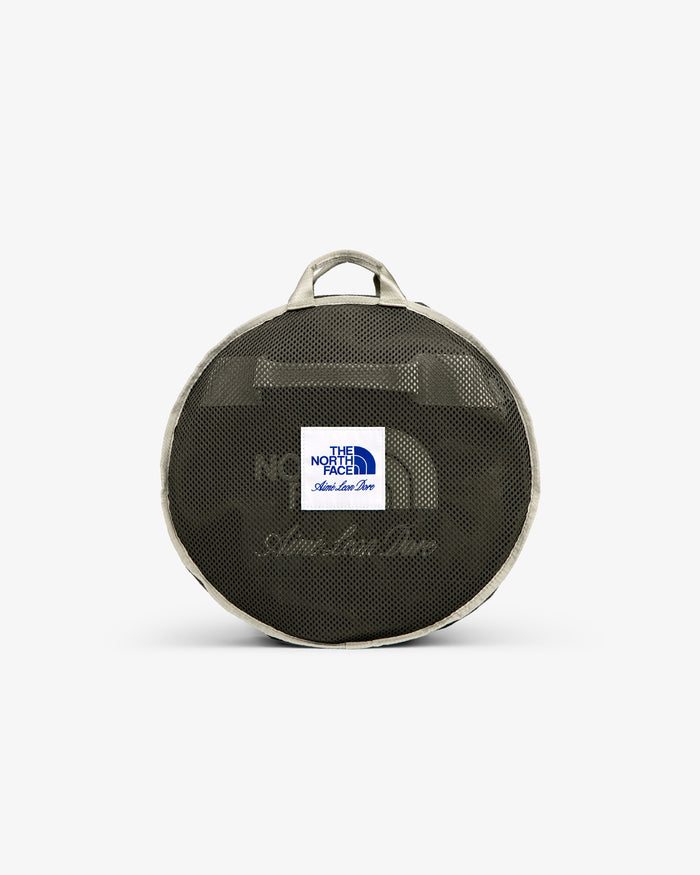 Small round mesh duffel with gray trim, handle, and white “The North Face” label—ALD / The North Face Base Camp Duffel.