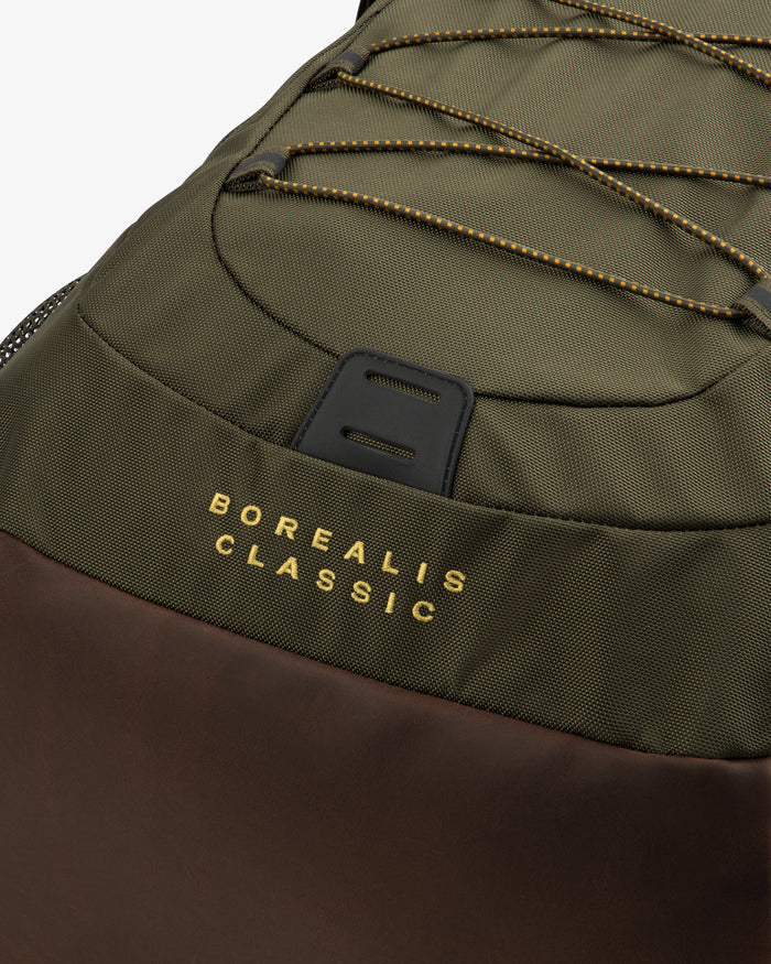 Close-up of the ALD / The North Face Borealis Backpack in olive and brown with yellow branding on the fabric.