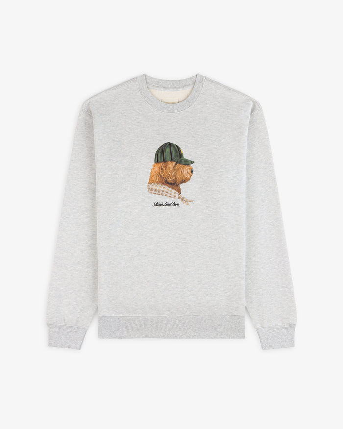 Buddy Crewneck Sweatshirt in grey featuring an embroidered dog with a green cap on the chest, shown on white background.