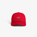 The Crest Logo Hat is a red baseball cap with AIMÉ and a small embroidered rose on the front, shown on a white background.