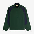 A dark green and navy Crest Nylon Half-Zip Pullover with beaded zipper pull, laid flat on a white background.