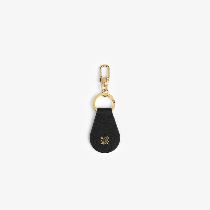 The Leather Key Fob is black leather with a gold clip, ring, and a small gold floral design at the bottom.