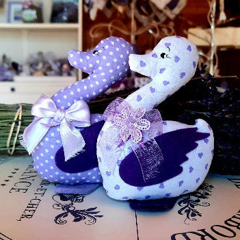 Paperella in stoffa nei toni del lilla decorata con nastrino. L'ochetta contiene fiori di lavanda.