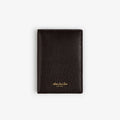 A closed black Tumbled Leather Passport Holder with gold text, resting on a plain white background.
